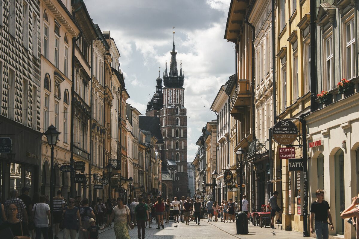 Zatłoczona ulica przy krakowskim rynku z widokiem na Kościół Mariacki